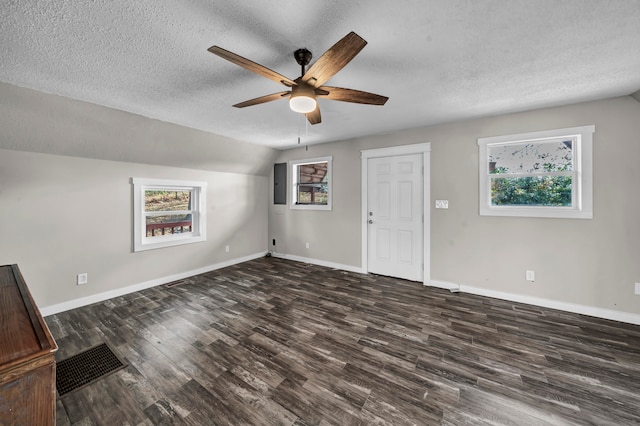 interior space with a textured ceiling, vaulted ceiling, dark hardwood / wood-style floors, and ceiling fan