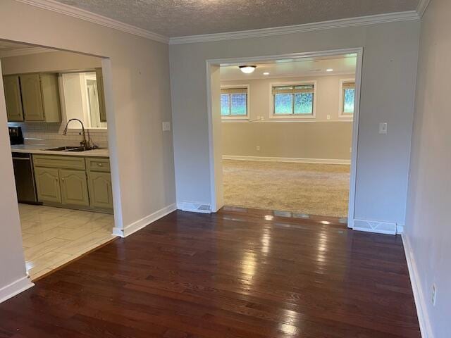 unfurnished dining area with hardwood / wood-style flooring, a textured ceiling, sink, and ornamental molding