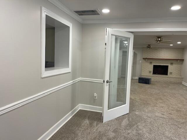 corridor with ornamental molding and carpet