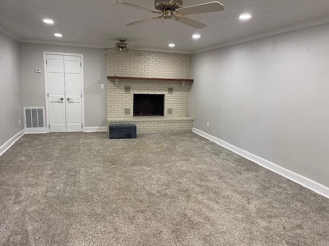 unfurnished living room with ornamental molding, carpet flooring, and ceiling fan