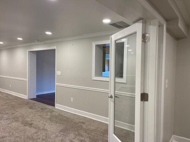 empty room featuring crown molding and dark carpet