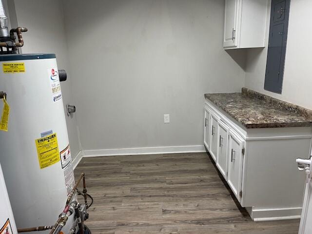 kitchen featuring white cabinetry, water heater, dark stone counters, and dark hardwood / wood-style flooring