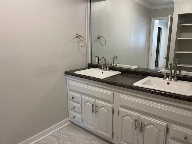 bathroom with vanity and ornamental molding