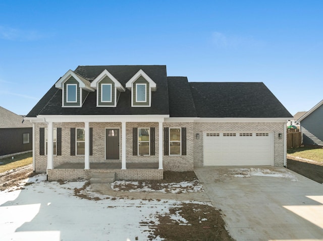 cape cod-style house featuring a garage and covered porch