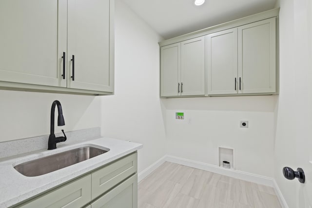 clothes washing area with electric dryer hookup, sink, washer hookup, and cabinets