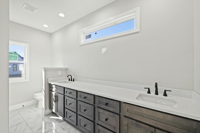 bathroom with vanity, a wealth of natural light, and toilet