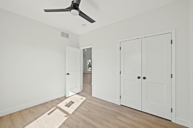 unfurnished bedroom with light hardwood / wood-style floors, a closet, and ceiling fan