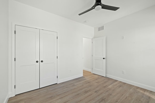 unfurnished bedroom with light hardwood / wood-style flooring, a closet, and ceiling fan