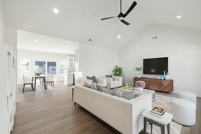 living room with high vaulted ceiling, light hardwood / wood-style floors, and ceiling fan