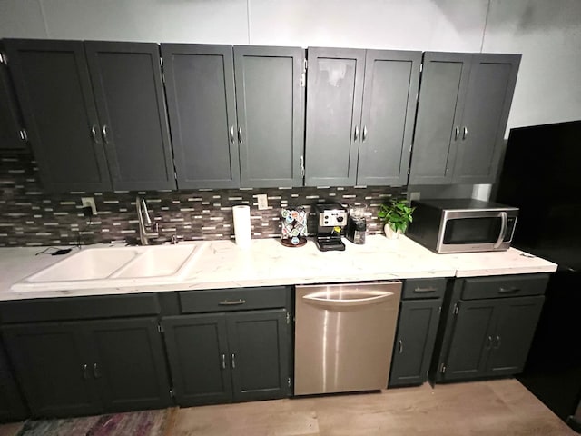 kitchen with sink, appliances with stainless steel finishes, gray cabinetry, and backsplash