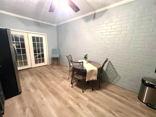 dining room featuring light hardwood / wood-style floors, ornamental molding, brick wall, and ceiling fan