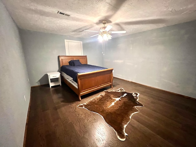 bedroom featuring ceiling fan, a textured ceiling, and dark hardwood / wood-style flooring