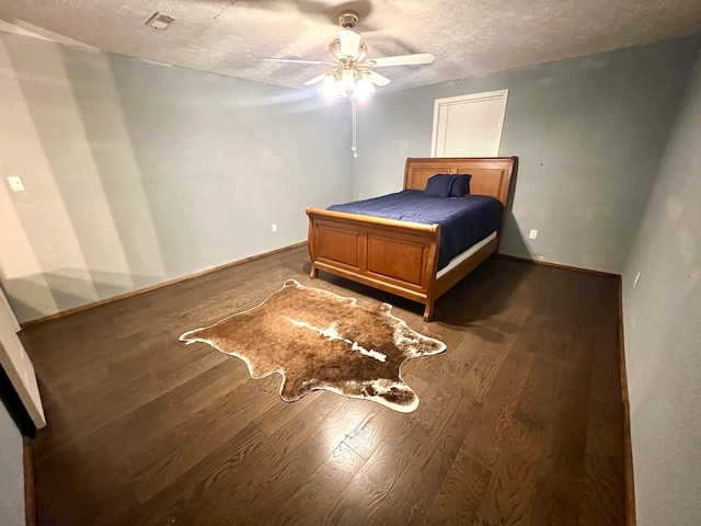 bedroom featuring ceiling fan, a textured ceiling, and dark hardwood / wood-style flooring