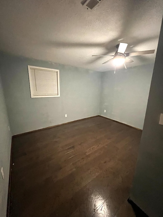 spare room with a textured ceiling, dark hardwood / wood-style floors, and ceiling fan