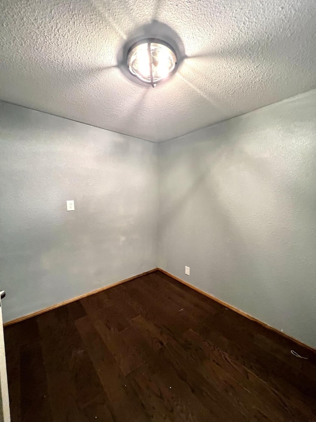 spare room featuring a textured ceiling and wood-type flooring