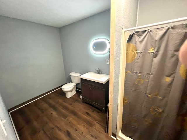 bathroom with vanity, toilet, walk in shower, and hardwood / wood-style floors