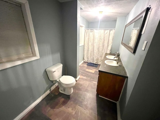 bathroom with hardwood / wood-style flooring, toilet, vanity, a textured ceiling, and walk in shower