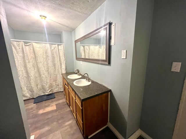 bathroom featuring vanity, hardwood / wood-style floors, and a textured ceiling