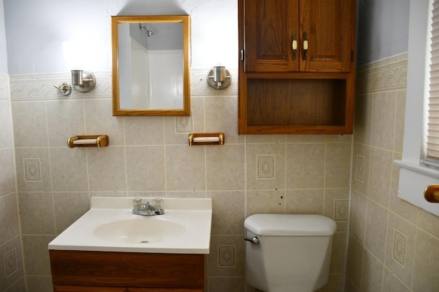 bathroom with tile walls, vanity, and toilet