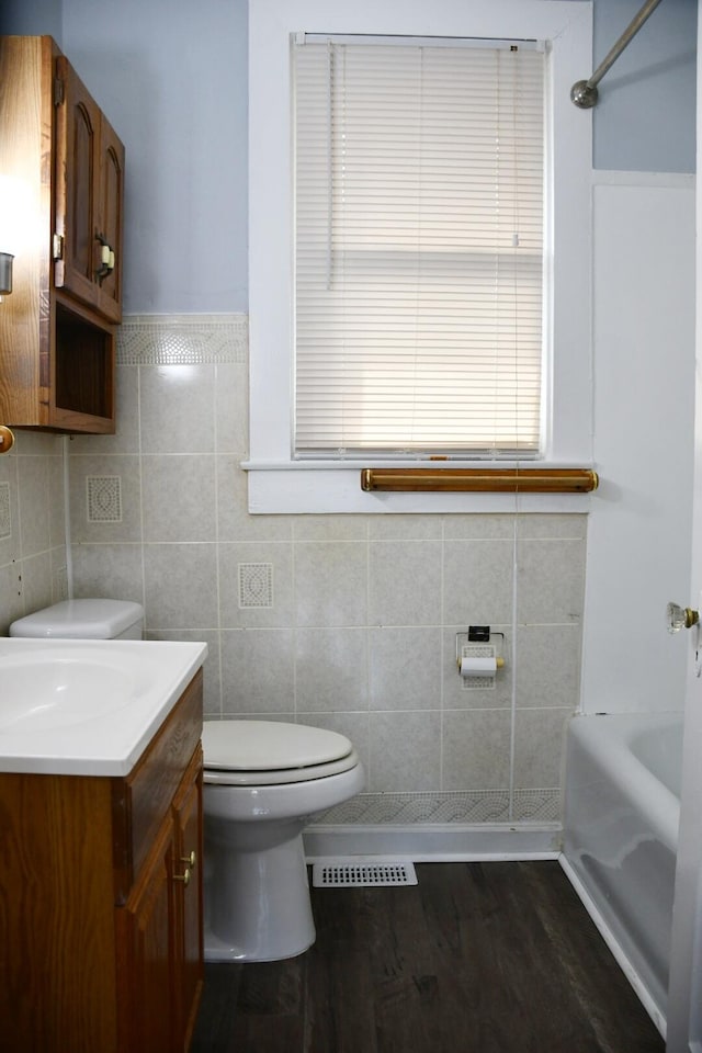 full bathroom with vanity, toilet, wood-type flooring, and plus walk in shower