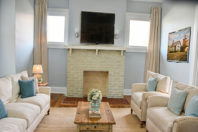 living room featuring a brick fireplace and hardwood / wood-style flooring