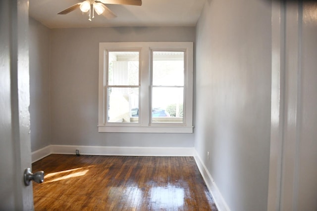 spare room with ceiling fan, dark wood-type flooring, and a wealth of natural light