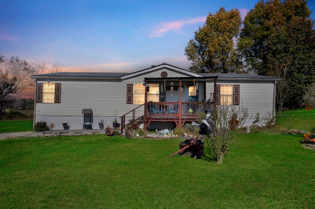 back house at dusk with a lawn