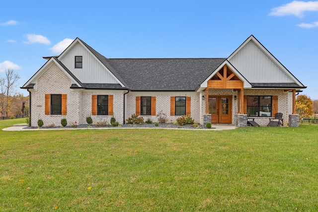 modern farmhouse featuring french doors, a front lawn, and brick siding