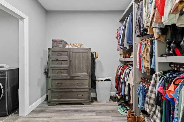 spacious closet featuring washer / dryer and light hardwood / wood-style floors