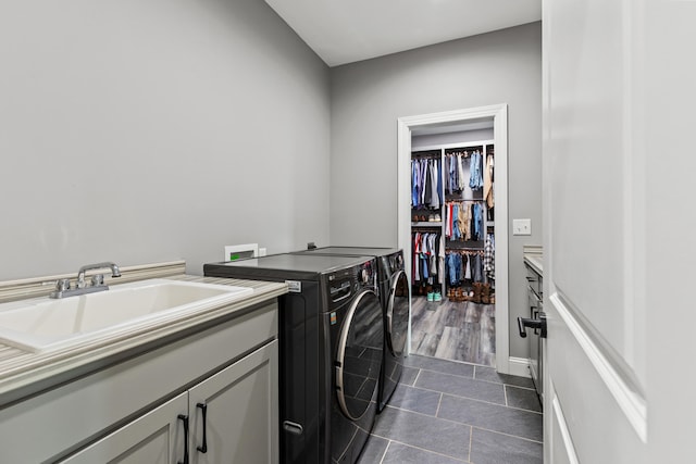 washroom featuring washer and clothes dryer, cabinets, dark tile patterned flooring, and sink