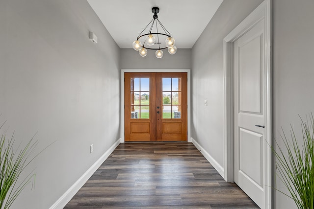 entrance foyer with dark wood-style floors, french doors, a notable chandelier, and baseboards