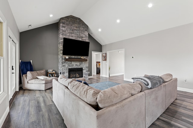 living room with high vaulted ceiling, dark hardwood / wood-style floors, and a stone fireplace