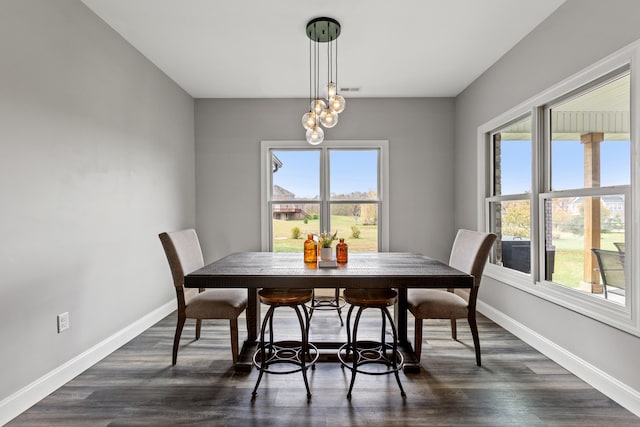 dining space featuring a notable chandelier, dark wood-style flooring, visible vents, and baseboards