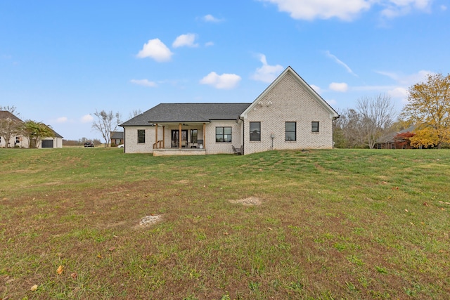 view of front facade featuring a front yard, brick siding, and a patio