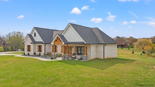 modern farmhouse style home featuring a shingled roof, a front lawn, and brick siding