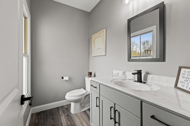 bathroom with baseboards, vanity, toilet, and wood finished floors