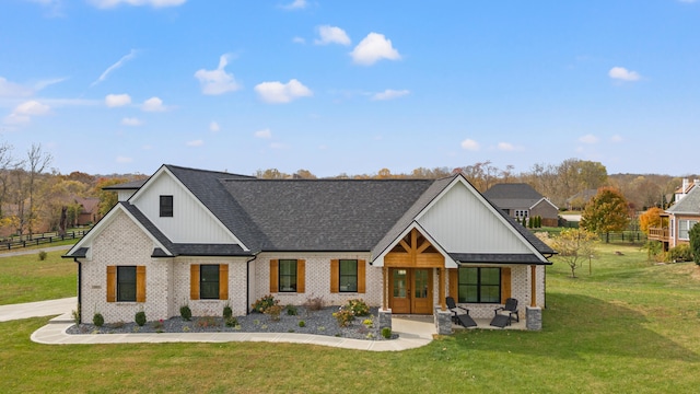 modern farmhouse style home featuring brick siding, a shingled roof, fence, french doors, and a front yard