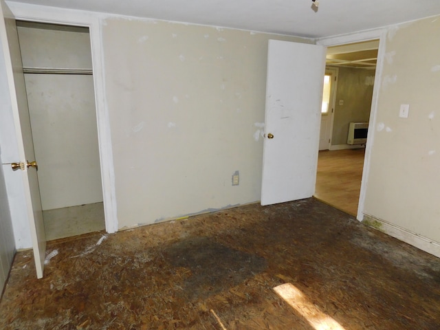 unfurnished bedroom featuring a closet and heating unit