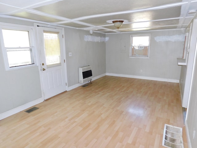 basement with light hardwood / wood-style floors and heating unit