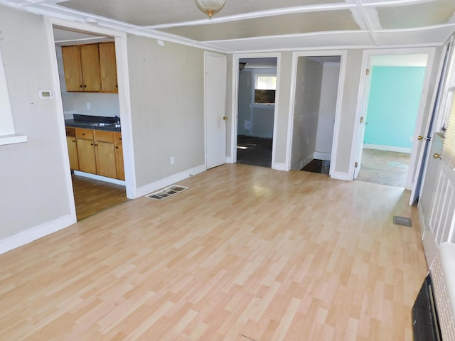 199 Caney Creek Rd, Stamping Ground, KY 40379 - empty room with visible vents, a sink, light wood-style flooring, and baseboards