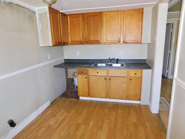 199 Caney Creek Rd, Stamping Ground, KY 40379 - kitchen with baseboards, dark countertops, a sink, and light wood finished floors