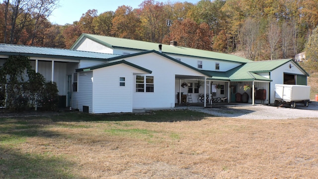 rear view of property featuring a yard and a patio area