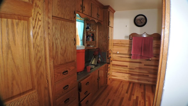 interior space with hardwood / wood-style floors and wooden walls