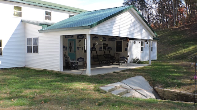 back of house with a patio and a lawn