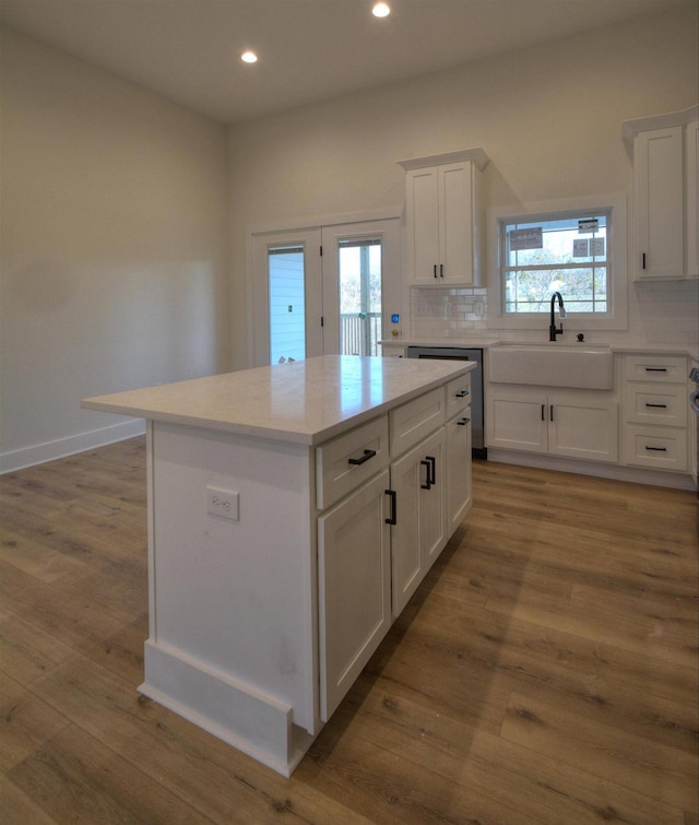 kitchen featuring white cabinetry, a center island, a healthy amount of sunlight, and sink