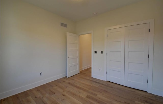 unfurnished bedroom featuring light wood-type flooring and a closet