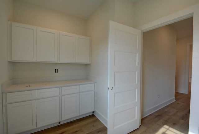 kitchen with light hardwood / wood-style flooring and white cabinets