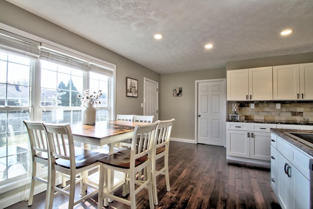 dining room with a textured ceiling and dark hardwood / wood-style floors