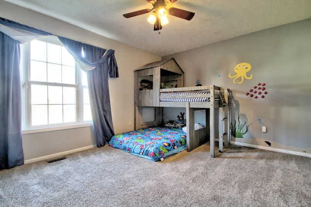 bedroom with ceiling fan, multiple windows, and carpet floors