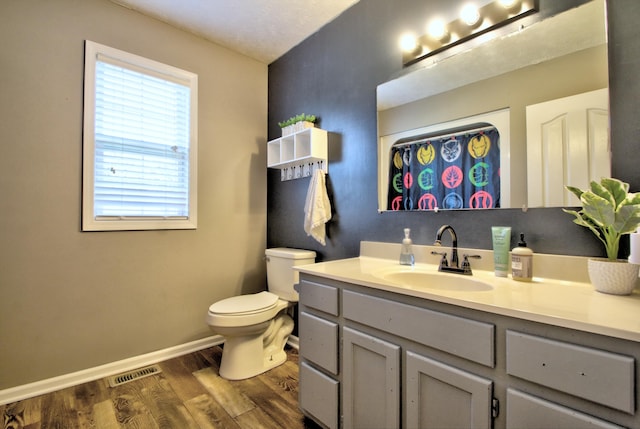 bathroom with vanity, a textured ceiling, wood-type flooring, and toilet